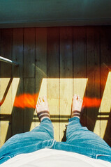Fototapeta na wymiar Wooden floor of an apartment in Paris, where the sun was lighting through the glass and projecting some shade on the feet a standing man.