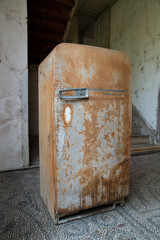 Nostalgic Westinghouse rusty disused refrigerator in old wooden house.