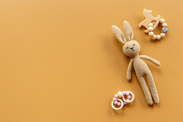 Knitted baby toy rabbit for newborn with wooden toys, top view