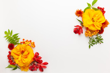 Autumn composition with flowers, leaves and berries on white background. Flat lay, copy space.