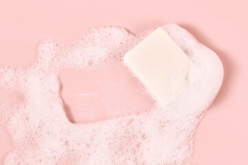 hand made soap in lush white foam on a pink background. cosmetic background minimalistic concept