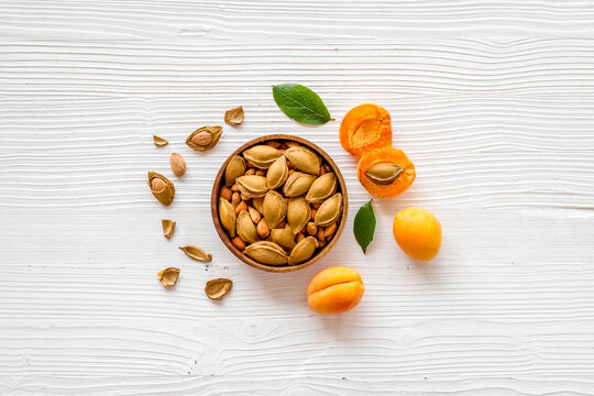 Apricots and apricot pits kernel in bowl. Overhead view