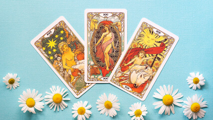 Fototapeta na wymiar Golden tarot cards on the Blue background with Daisy flowers, Star, sun, peace