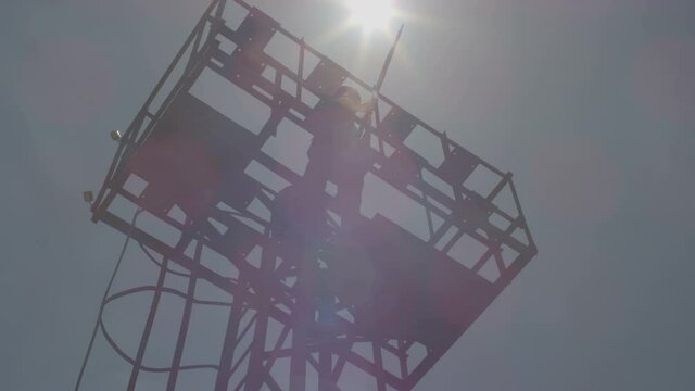 Security , guard , policeman stay in watch tower and looking arround with not licensed decorative uniform and weapon . Silhouette of guard tower or prison tower with security man . Slow Motion . 