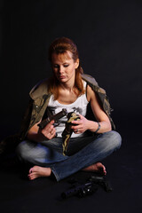 blonde woman in camouflage with arms on a dark background with studio