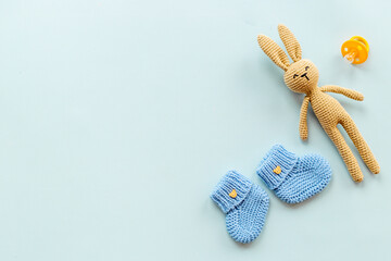 Kids toy knitted rabbit with baby booties shoes, top view