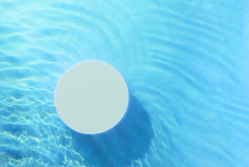 Top view of empty round podium in transparent waves of water on blue background. Blank summer...