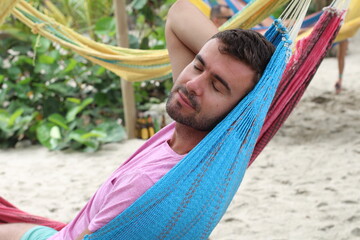 Guy enjoying a hammock in topical island