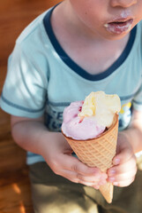 Little child eating ice cream cone on sunny summer day. Food or dessert in heat weather,...