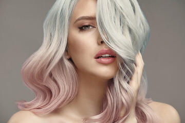 Pink and blue hair color on head of female beauty model.