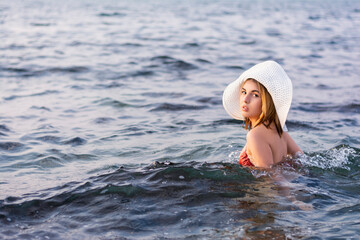 Fototapeta premium Portrait of beautiful young woman traveler in hat and swimsuit on vacation summer vacation