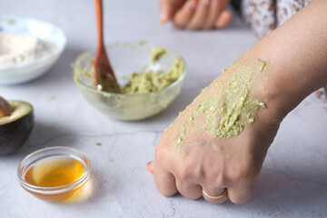 women applying homemade natural avocado cosmetic cream on skin,