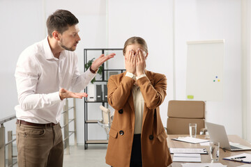 Man scolding woman in office. Toxic work environment