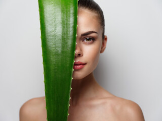 portrait of sexy woman with green aloe leaf bare shoulders clear skin model