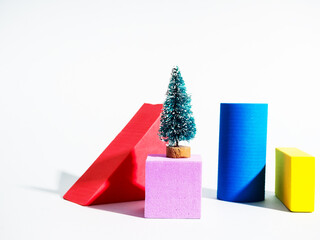 Gift card with green small toy christmas tree on yellow figure for concept design. House decoration.