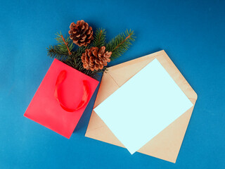 Beautiful greeting card. Holiday concept. Beautiful blue background next to it is a red bag with fir branches