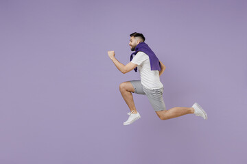 Full size body length side view profile young brunet man 20s wear white t-shirt purple shirt jump like running isolated on pastel violet background studio portrait. people emotions lifestyle concept.