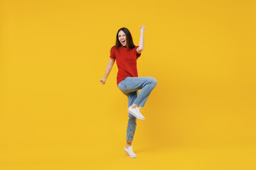 Fototapeta na wymiar Full size body length happy excited young brunette woman 20s wears basic red t-shirt doing winner gesture celebrating isolated on yellow background studio portrait. People emotions lifestyle concept.