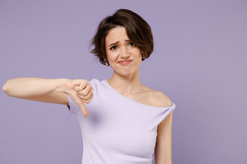 Young disappointed dissatisfied displeased woman 20s with bob haircut in white t-shirt show thumb...