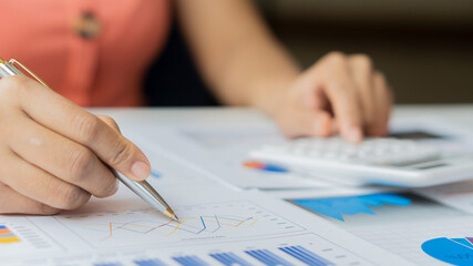 Accountant using computer with clamp and graph document, business man working on desk using calculator to calculate numbers, financial accounting concepts.