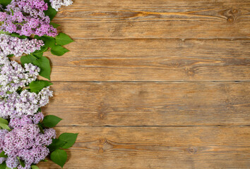 Old rustic wooden background with lilac flowers and copy space