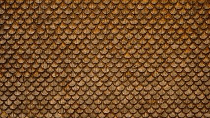 Traditional ecological  consistent cladding of a wall with brown wooden larch fish scales, wood...