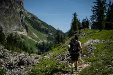 Fototapeta na wymiar Junger Mann wandert bei schönem Wetter in den Bergen in Österreich Steiermark