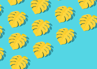 Creative summer pattern made of yellow monstera leaves on bright bastel blue. Minimal tropical pattern with diagonal copy space.