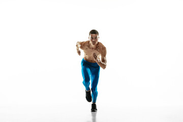 Front view of Caucasian professional male athlete, runner training isolated on white studio background. Muscular, sportive man. Concept of sport, healthy lifestyle