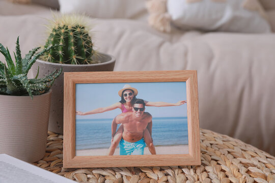 Framed photo of happy couple on wicker table in living room