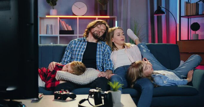 Attractive Excited Blond Mother Waking Her Sleepy Family When They Together Fell Asleep In Front Of TV Because Wanted To Watch Interesting Tv-show