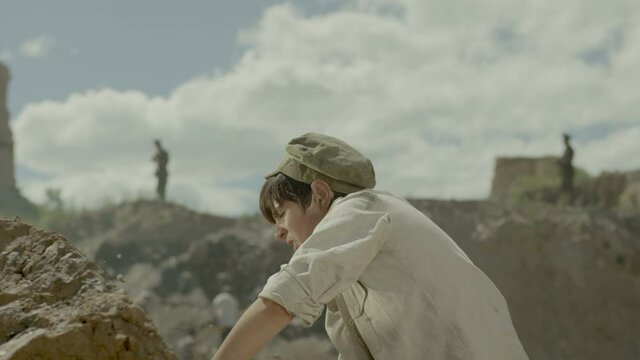 Young miner boy is working in a quarry . Group of many workers are mining with pickaxe in a quarry . Scenic shot in vintage style with artists . Shot on RED EPIC Cinema Camera in slow motion.