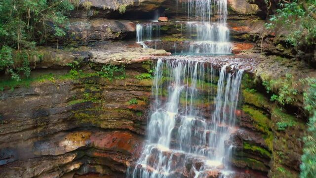 Camera pans up and over multi-layered Elephant Falls
