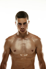 Fototapeta premium Portrait of young muscular man, male athlete, runner isolated on white studio background. Concept of sport, healthy lifestyle. Power and beauty