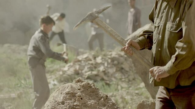 A group of miners or gold diggers are working . Many workers are mining with pickaxe in a quarry . Scenic shot in vintage style with artists . Shot on RED EPIC Cinema Camera in slow motion.