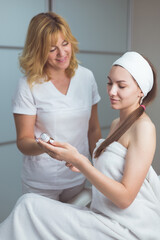 Obraz premium The beautician recommends a cosmetic product to the client