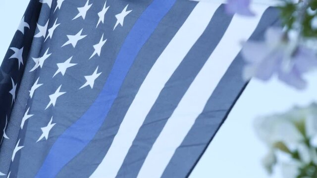 Black white american monochrome flag with blue stripe or line, police support. Solid star-spangled banner waving in wind breeze.