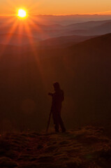 Obraz premium A photographer watching the sunrise at the top of Połonina Wetlińska, Bieszczady Mountains, Carpathians