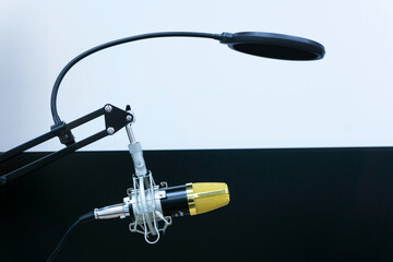 Golden microphone for music or radio on a black and white background 