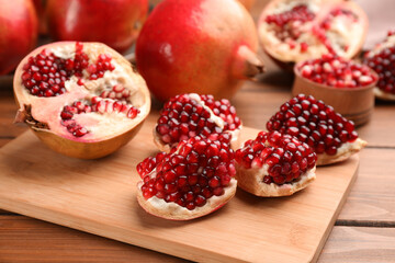 Delicious fresh ripe pomegranates on wooden table
