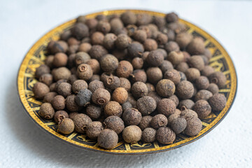 tray full of allspice isolated on white, selective focus macro