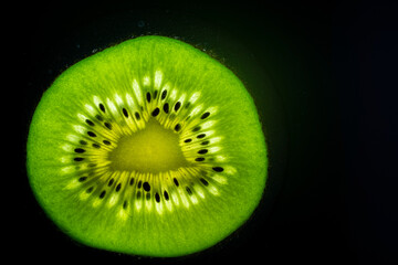slice of a kiwi fruit lit from under, macro