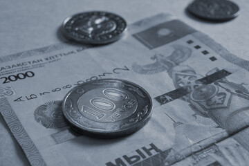 Kazakh money. A bill in 2000 tenge, a coin in 100 tenge and others. A coin of the sample of 2019 with inscriptions in Latin. Gray-blue background or wallpaper about the economy and banks. Close up