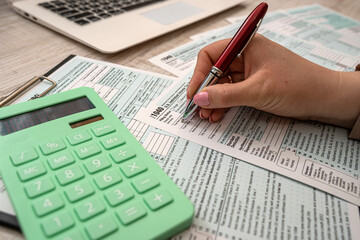 woman fills in individual tax form 1040