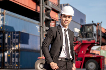 Happy Asian businessman working with smile servic in shipping containerin commercial transport background.