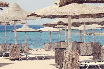 Beautiful beach. sun beds and umbrellas on the sandy beach by the sea. Summer holidays and the...