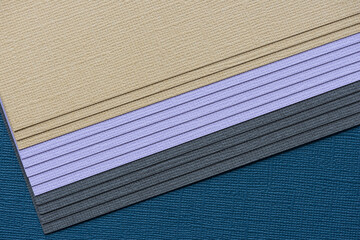 sand, lavender, dark gray, and navy blue paper background