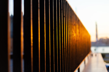 Black iron fence at sunset. Business center fence grating in summer
