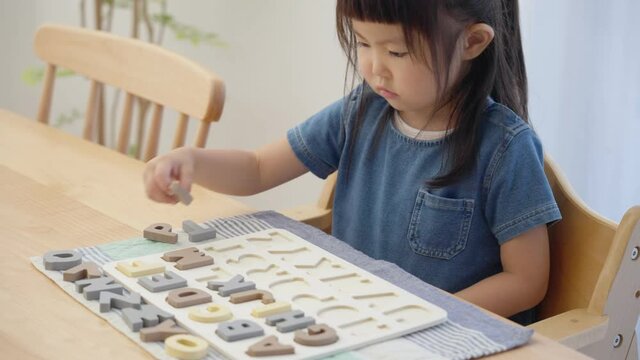 アルファベットパズルで英語の勉強をする子供