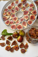 Fresh figs lie on the table next to dried figs in a glass jar. Top view